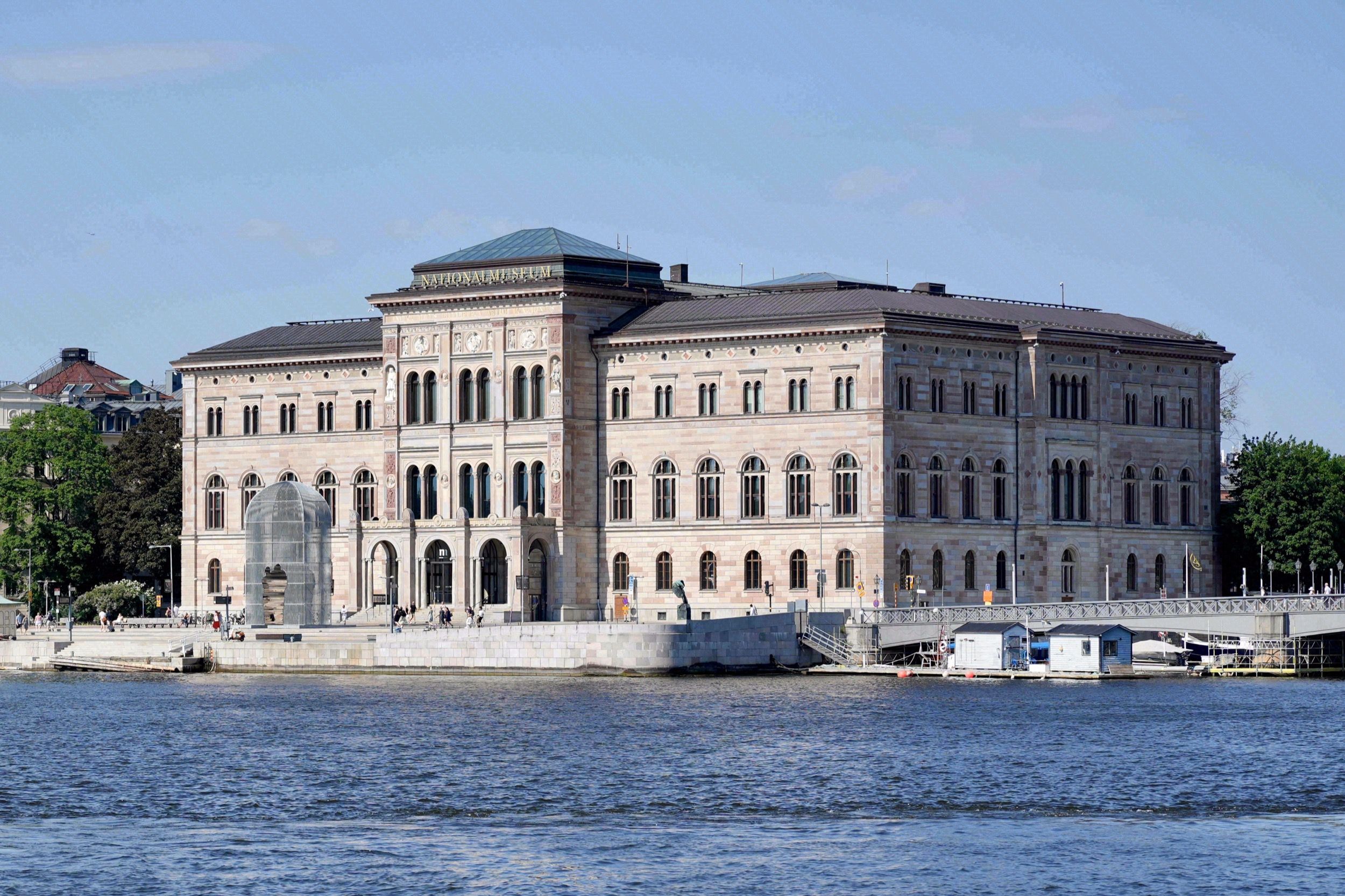 Das Nationalmuseum vom Wasser aus mit seiner imposanten Rundbogenfassade aus rotem Sandstein auf der Halbinsel Blasieholmen.
