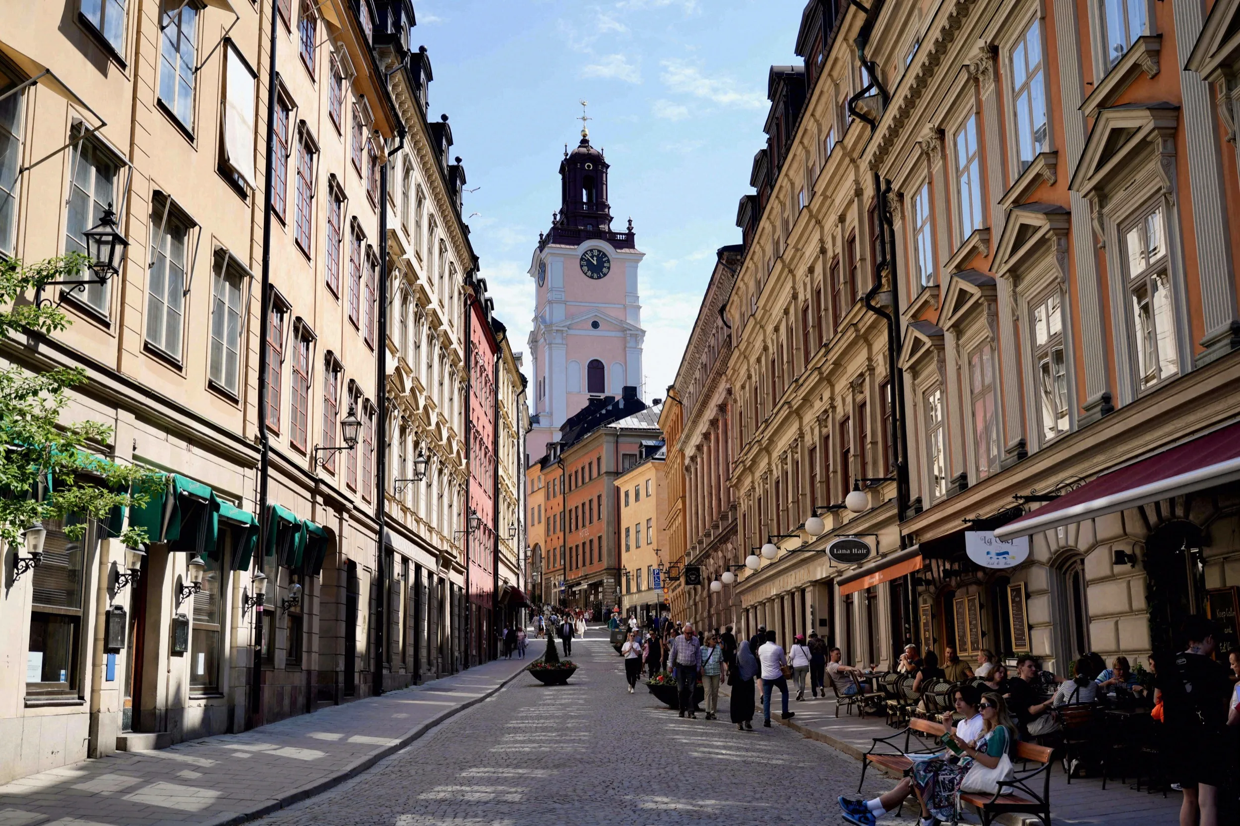 Blick durch die belebte Västerlånggatan auf den weißen Turm der Storkyrkan