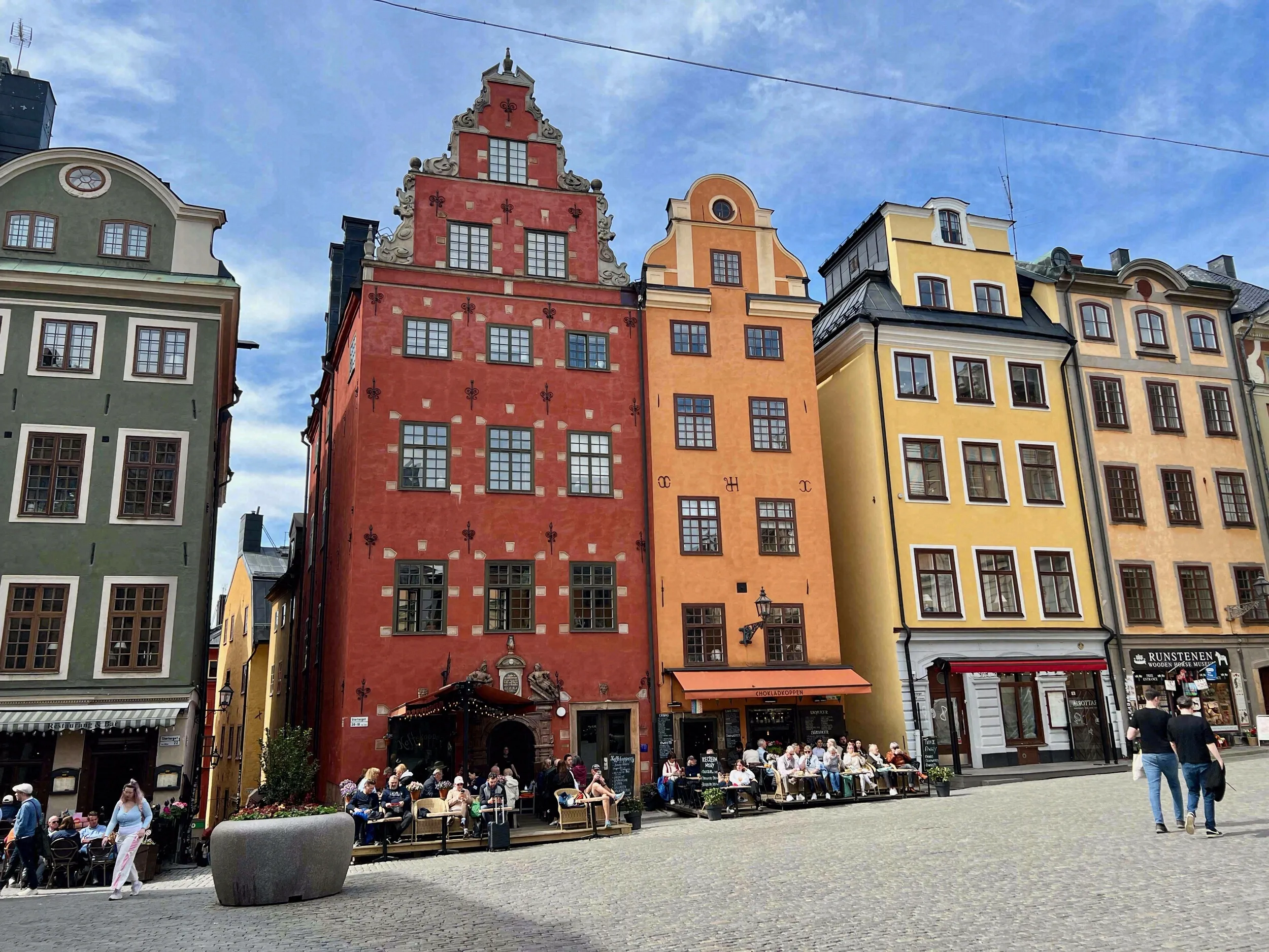 Die farbenfrohen Giebelhäuser am Stortorget in Rot, Orange und Gelb mit Cafés im Erdgeschoss