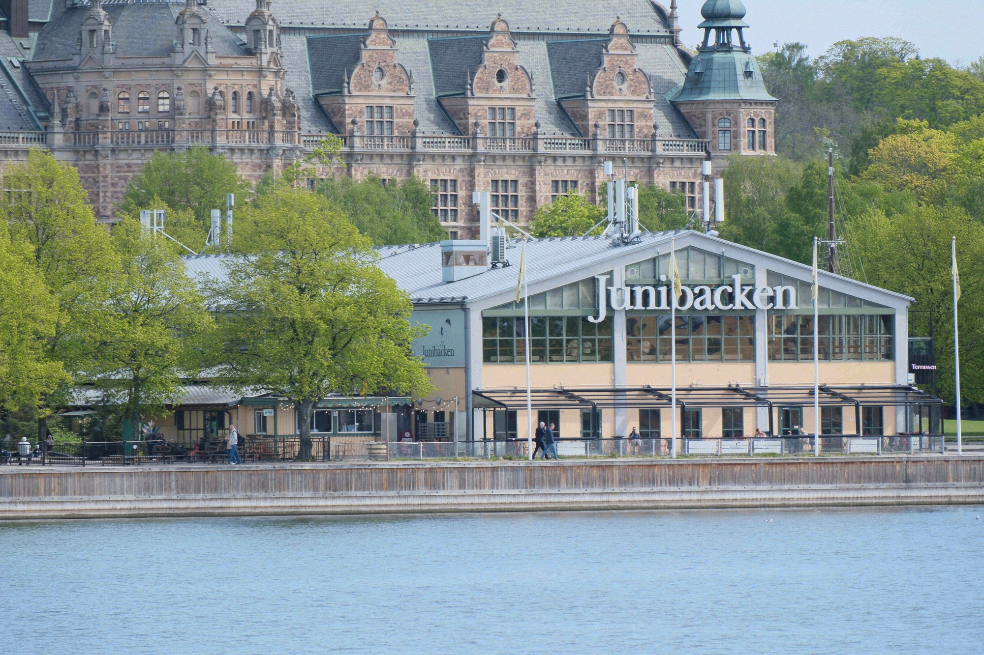 The Junibacken children's museum on Djurgården seen from the water, with the neo-Gothic Nordiska museet building behind it.