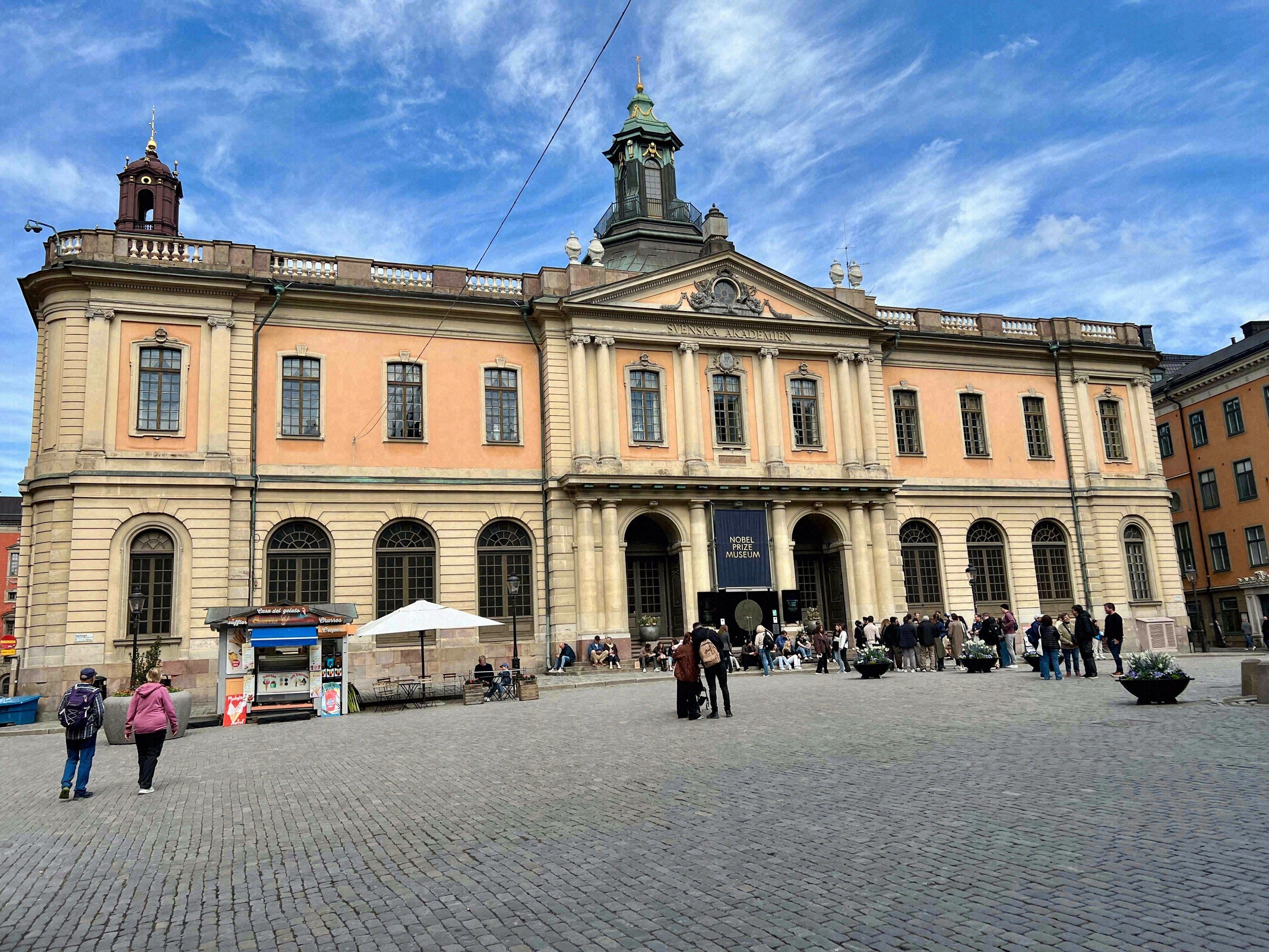 Facade of the Nobel Prize Museum on Stortorget in Gamla Stan, with the striking orange baroque former Stock Exchange building.