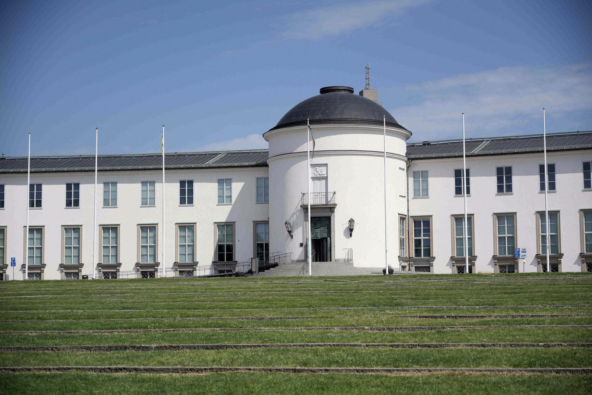 Front view of the Sjöhistoriska museet (Maritime Museum) with its distinctive white facade, black dome and flagpoles.