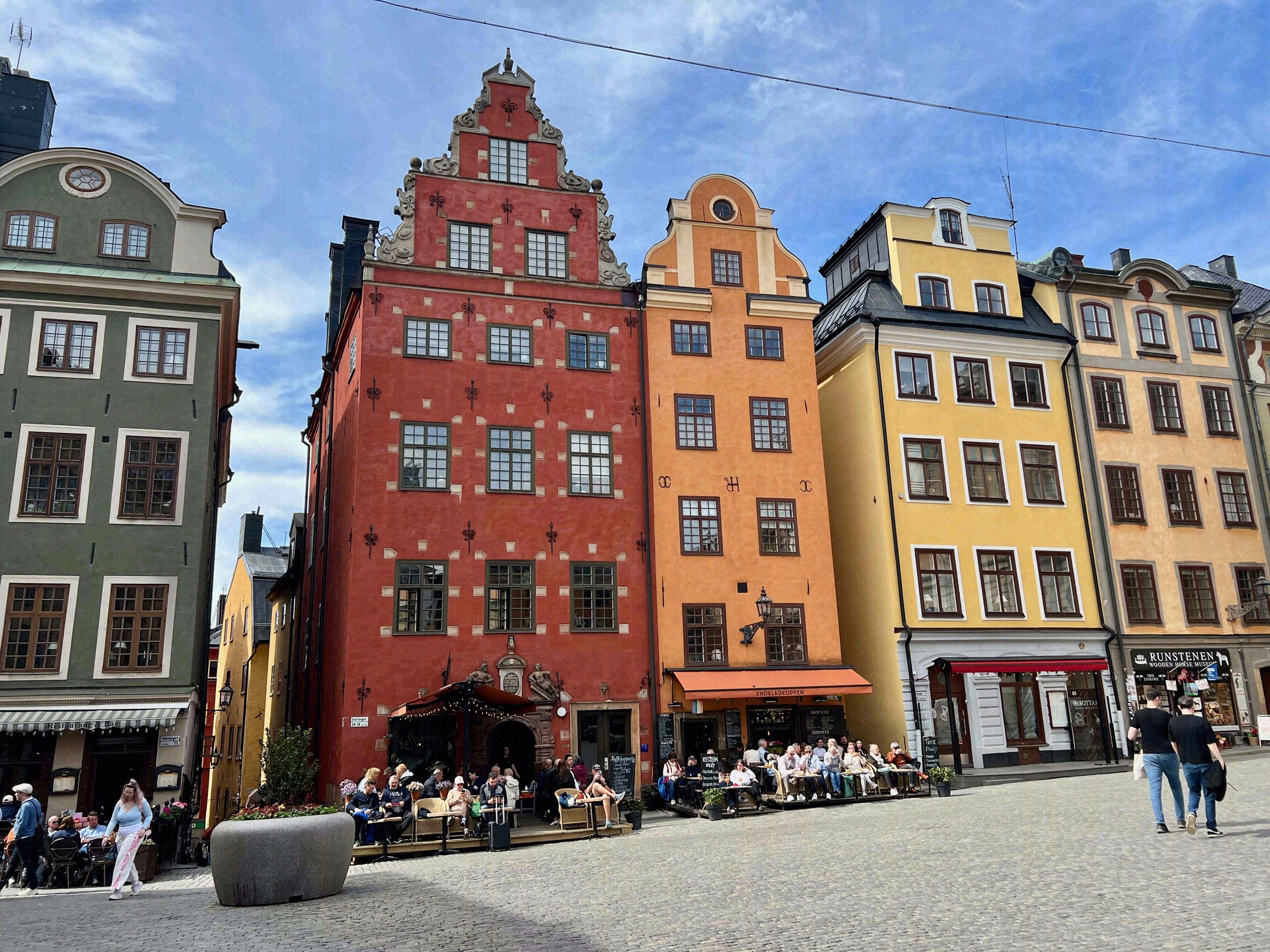 The colourful gabled houses on the west side of Stortorget. The colourful gabled houses on Stortorget in red, orange and yellow, with cafés at street level